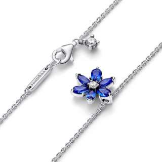 Bleščeča ogrlica z modrim obeskom, ki so jo navdihnili v herbariju stisnjeni cvetovi in listi 